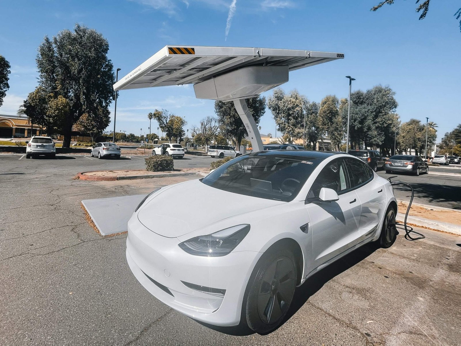 Opladen van een Witte Elektrische Auto bij het Laadstation