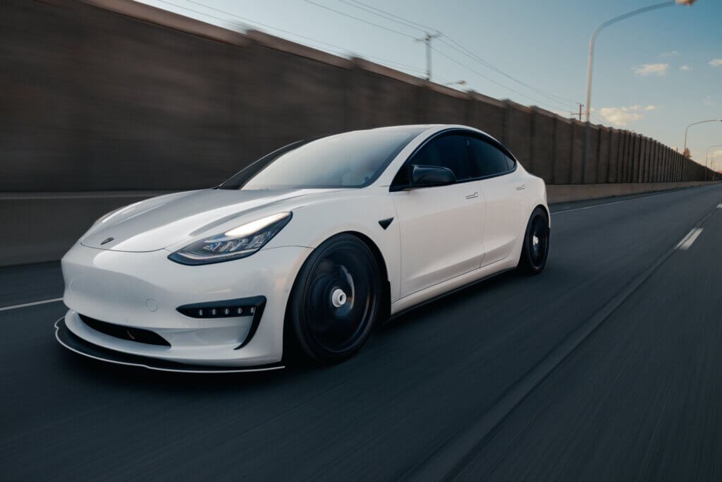 Elektrische witte Tesla in beweging op de weg